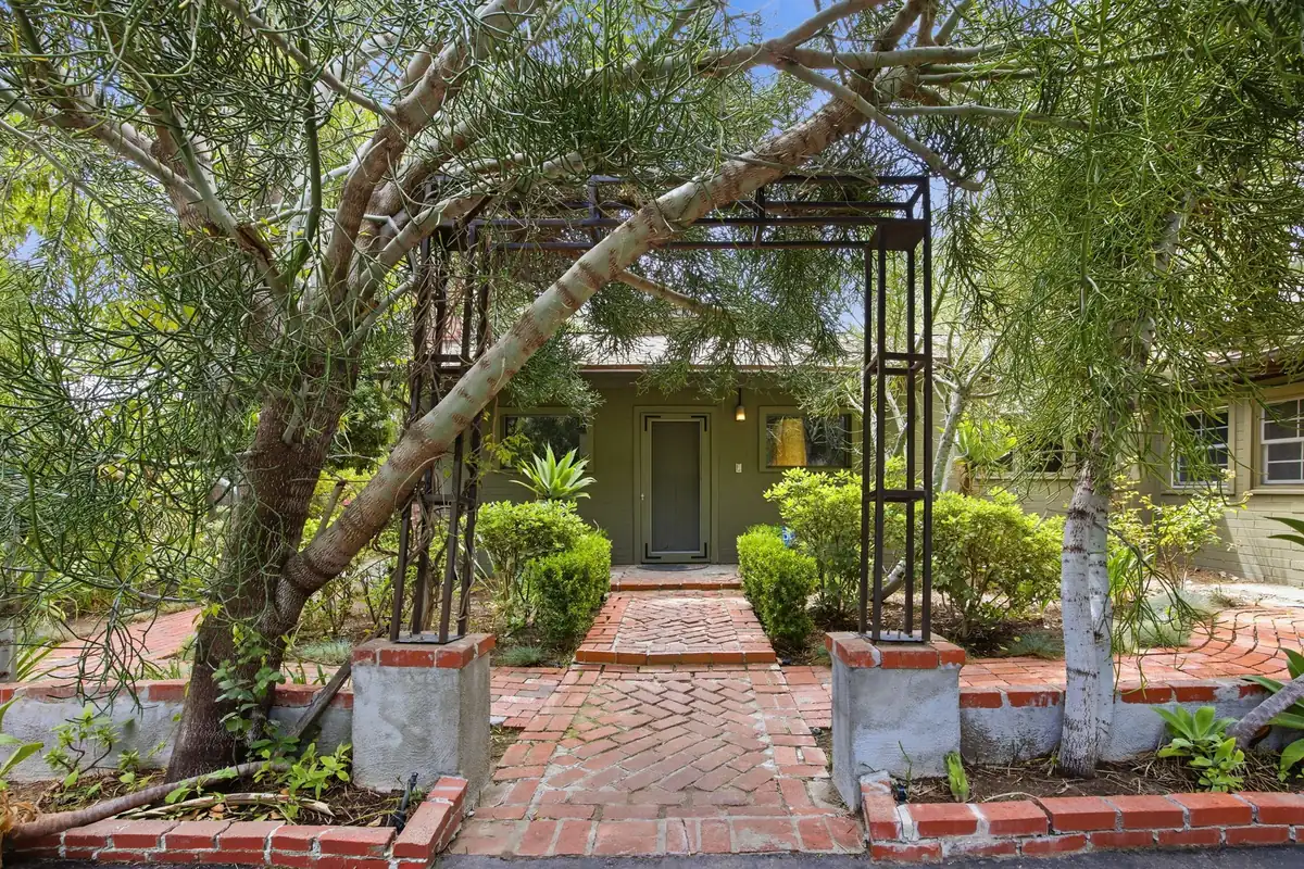 Brick path and metal arbor leading to the front door of the Granada Hills home