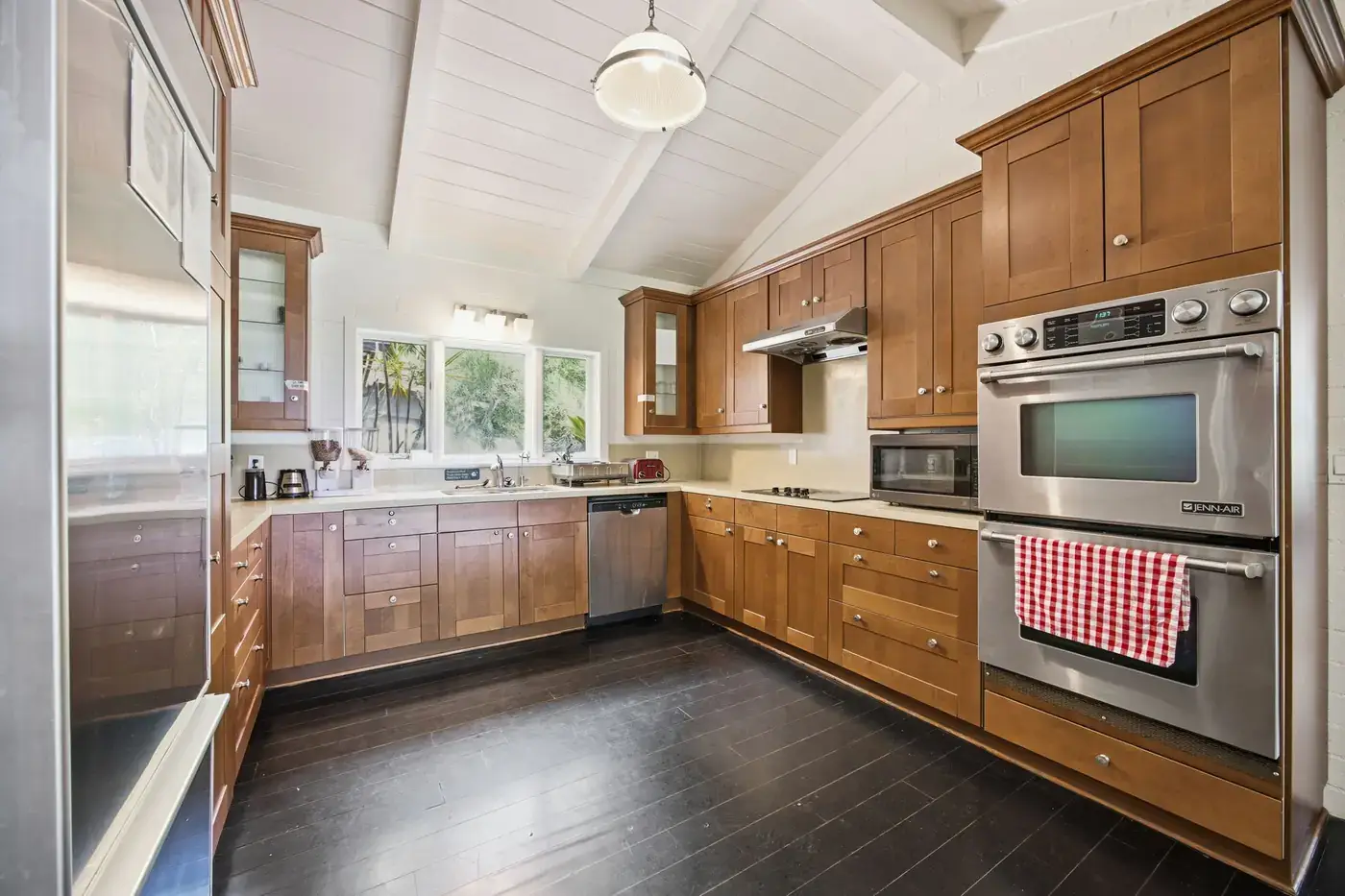 Full kitchen with wood cabinets, steel appliances and double ovens
